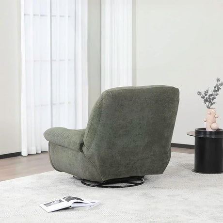 Green reclining chair on light rug beside round black table and vase in modern living room
