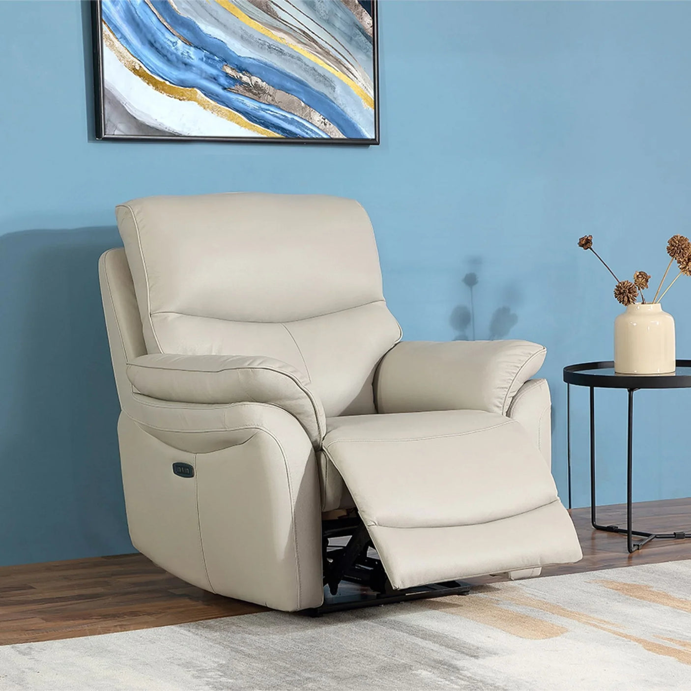 Light grey leather recliner chair with footrest extended beside a black round side table