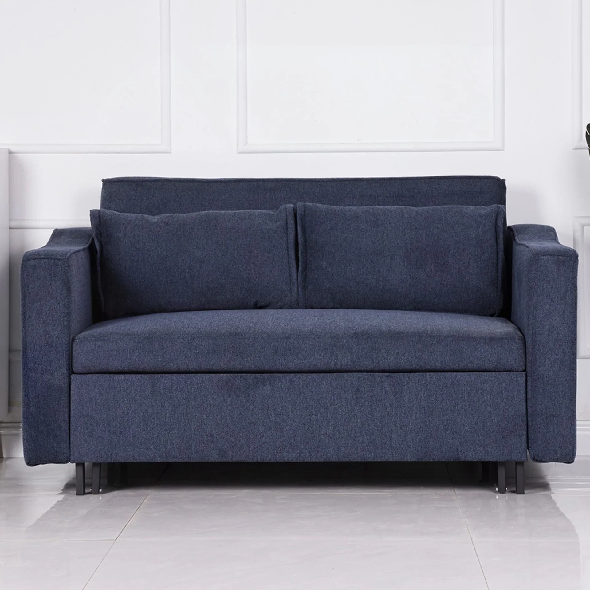 Denim blue sofa bed with two cushions and square arms on tiled floor
