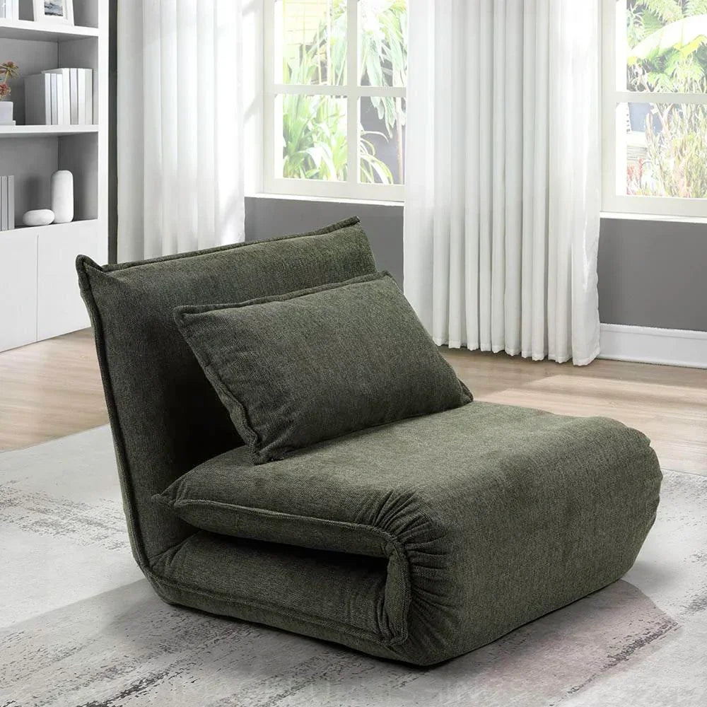 Corso sofa bed in winter moss fabric with cushion, shown in modern living room by window