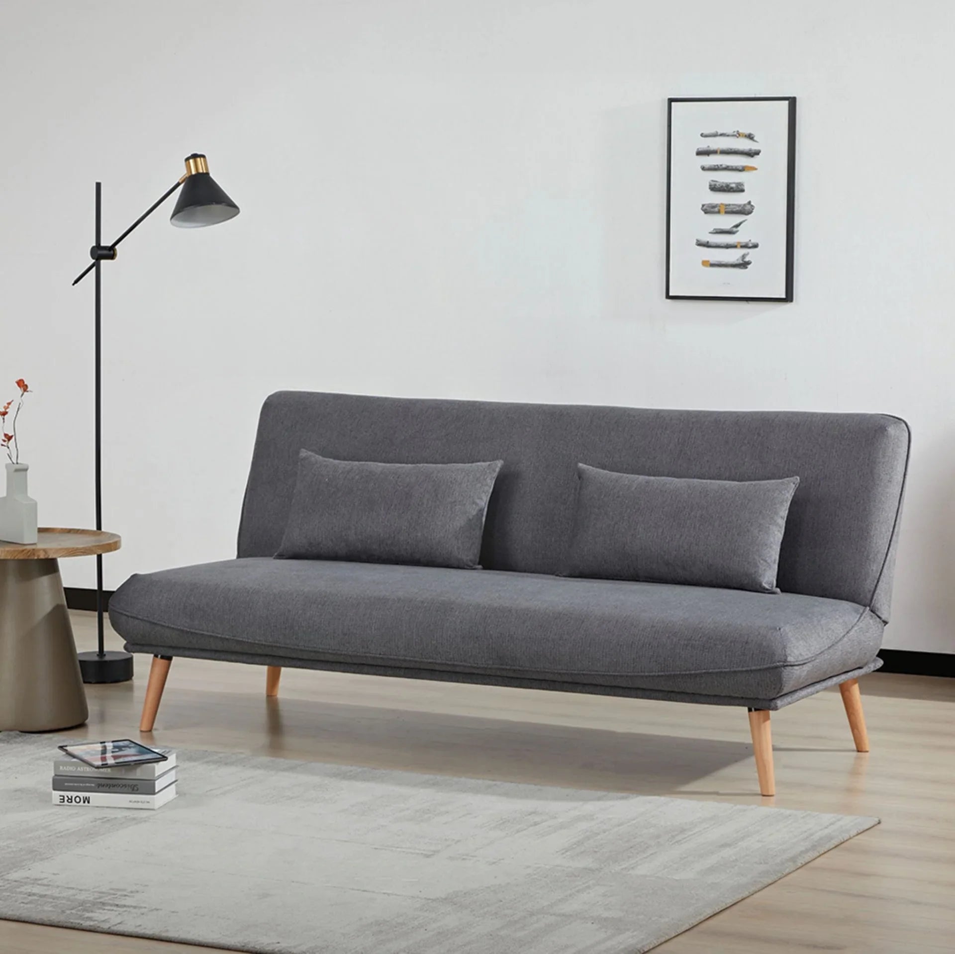 Dark grey sofa bed with two cushions, wooden legs, set in modern living room