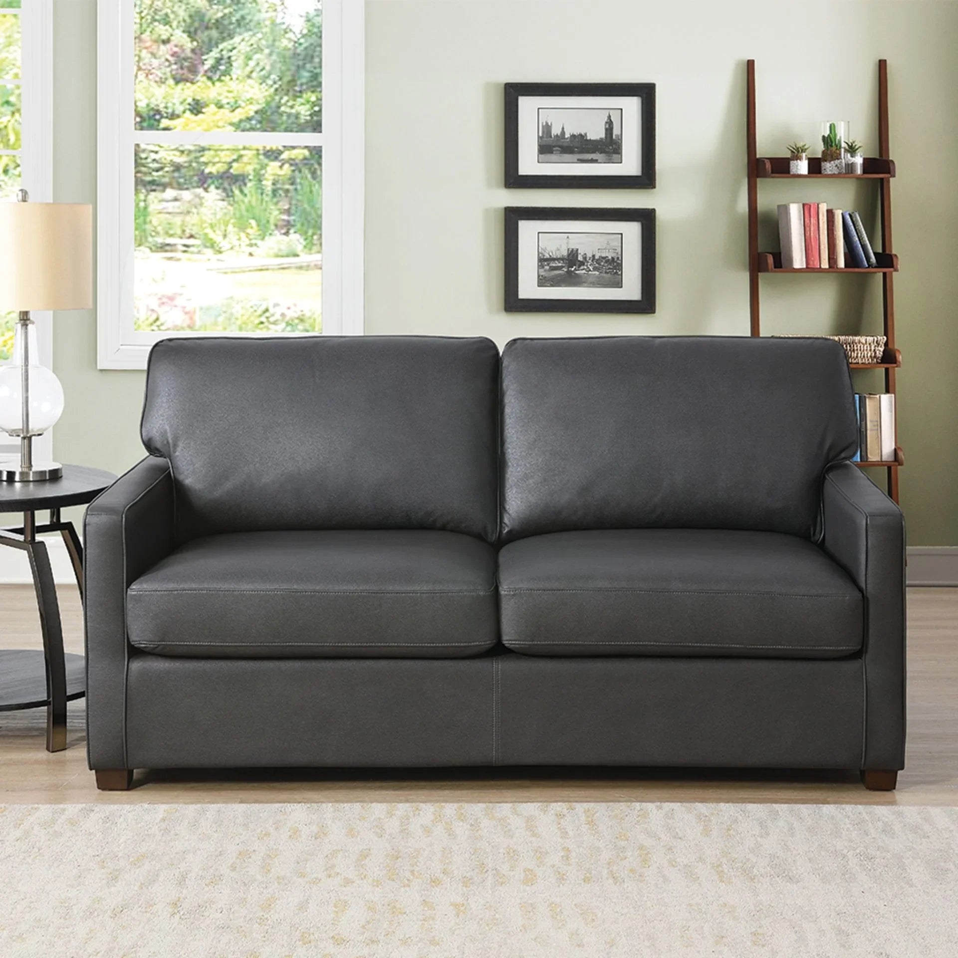 Grey sofa bed with straight arms and wooden legs in a bright living room setting