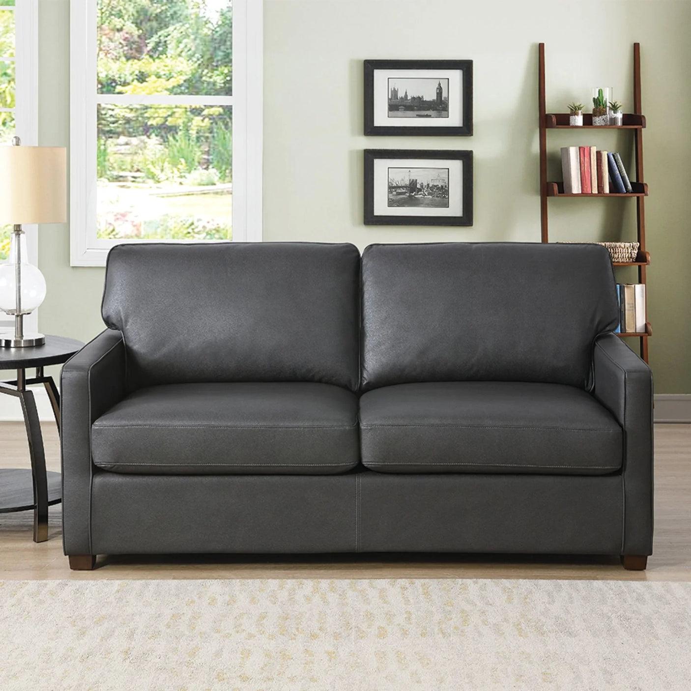 Grey sofa bed with straight arms and wooden legs in a bright living room setting