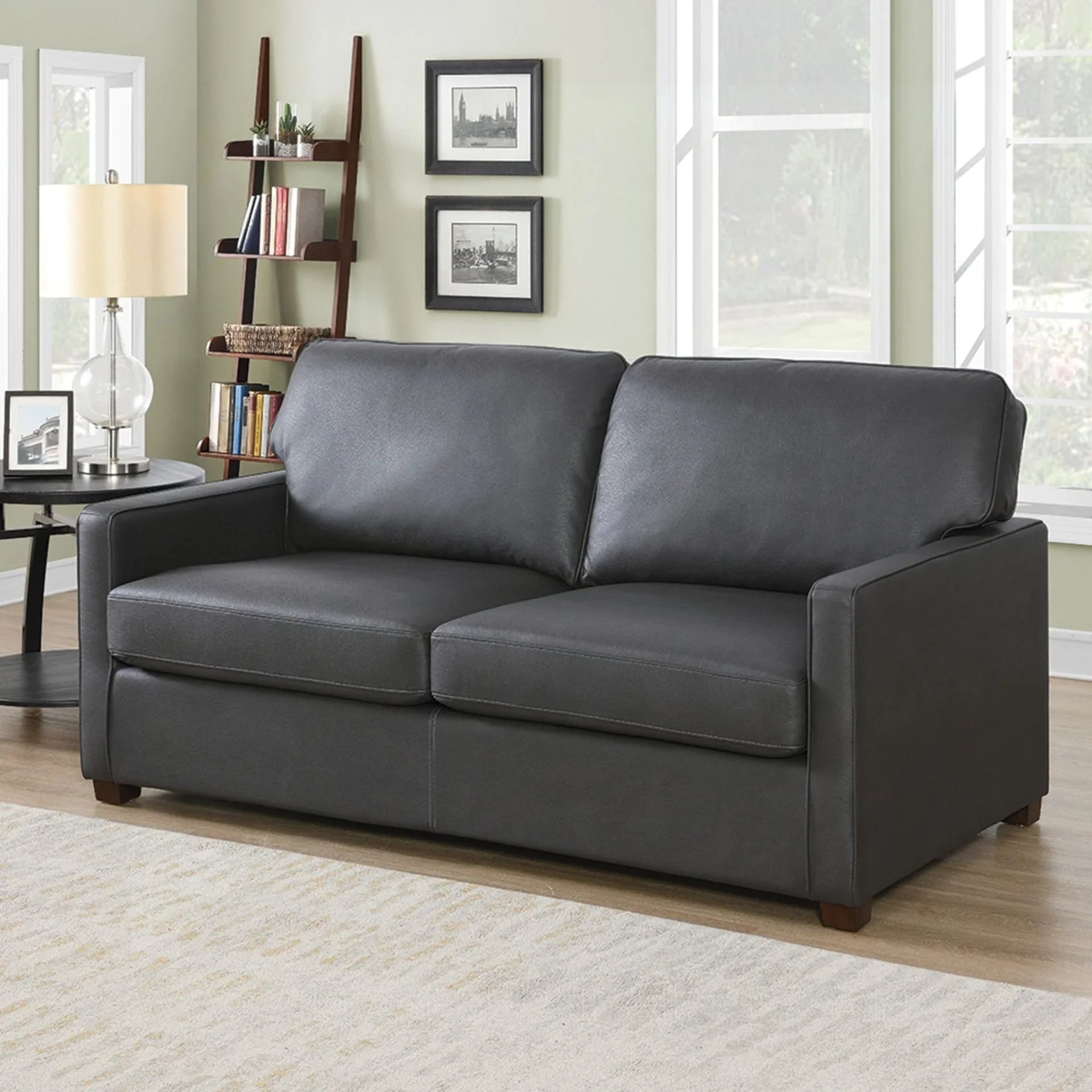 Grey sofa bed with straight arms and plush cushions in a bright living room