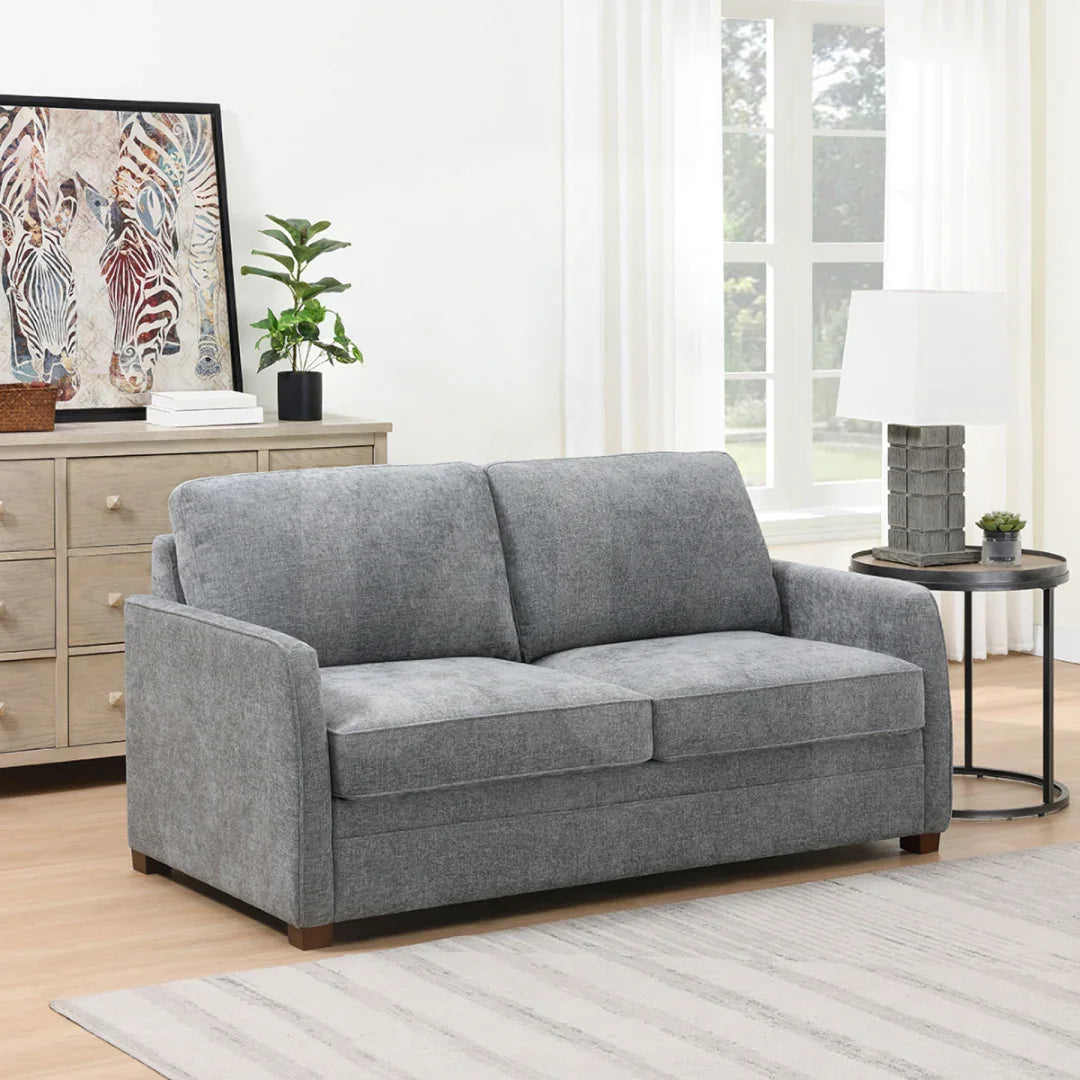 Grey full foam sofa bed in modern living room with light wood flooring and neutral decor