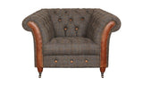 Brown tweed armchair with button-tufted back, leather trim, and wooden legs on castors