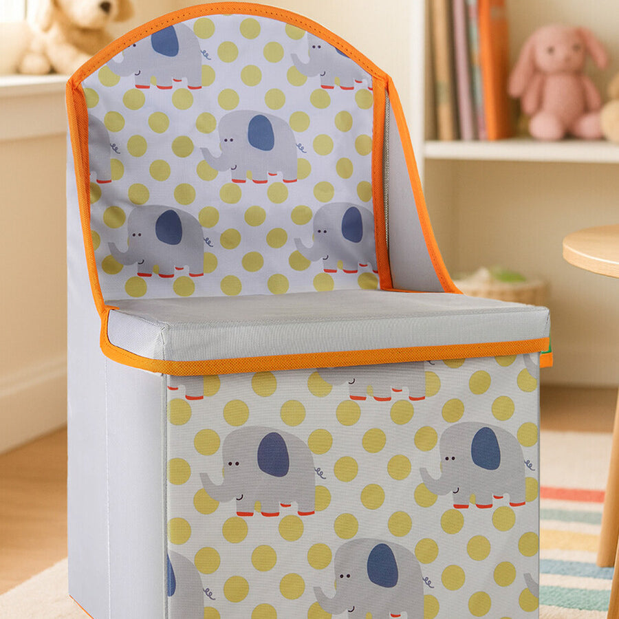 A children's storage seat featuring a playful elephant design on a yellow and white polka dot background, with an orange trim. The seat has a hinged lid that opens to reveal storage space inside, and it is placed in a bright, cheerful room with a soft rug and plush toys in the background