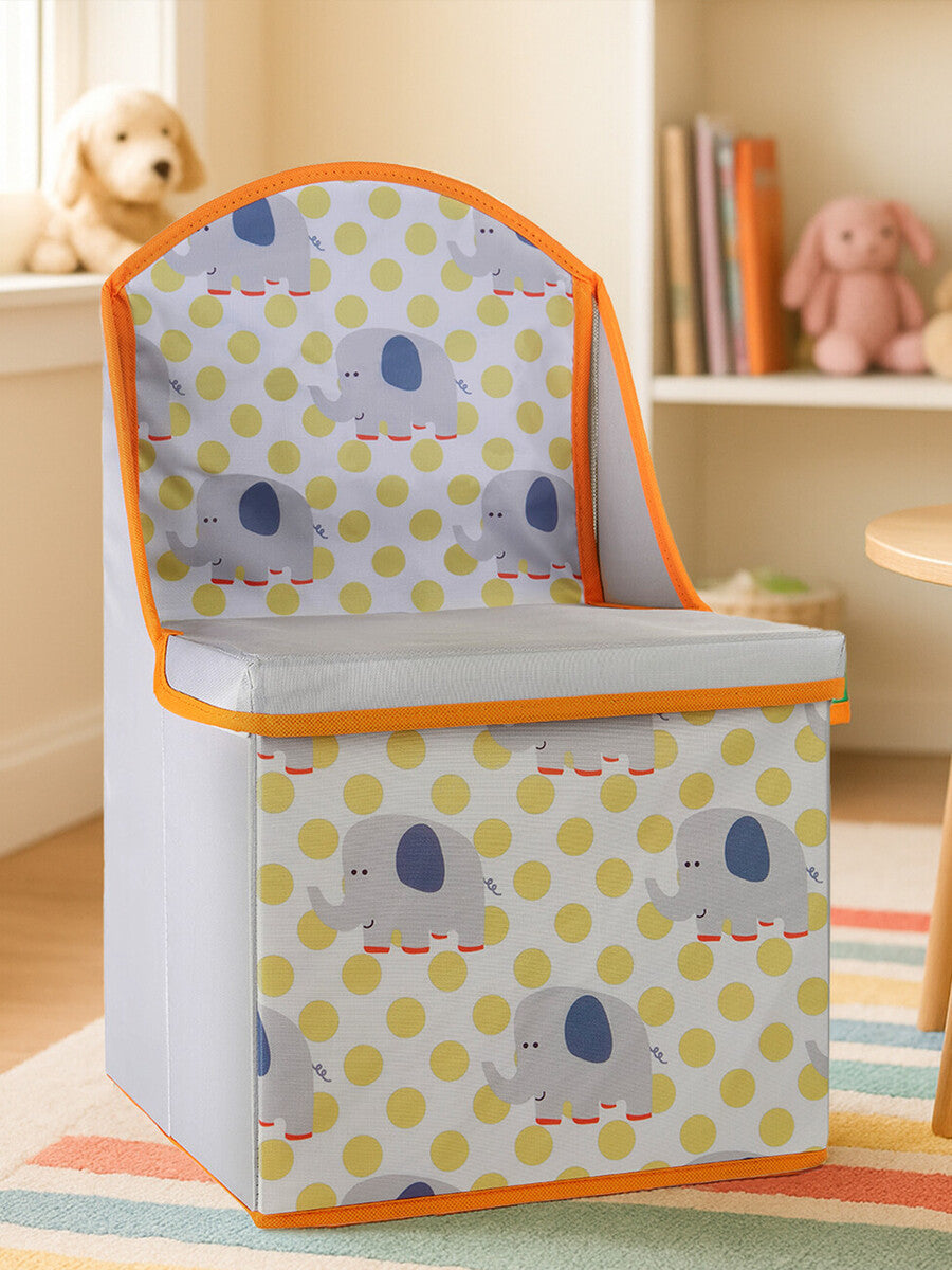 A children's storage seat featuring a playful elephant design on a yellow and white polka dot background, with an orange trim. The seat has a hinged lid that opens to reveal storage space inside, and it is placed in a bright, cheerful room with a soft rug and plush toys in the background