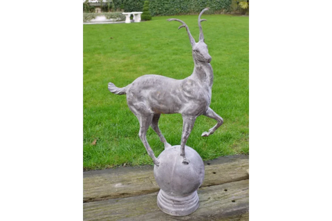 antelope statue garden ornament on stone base displayed on lawn