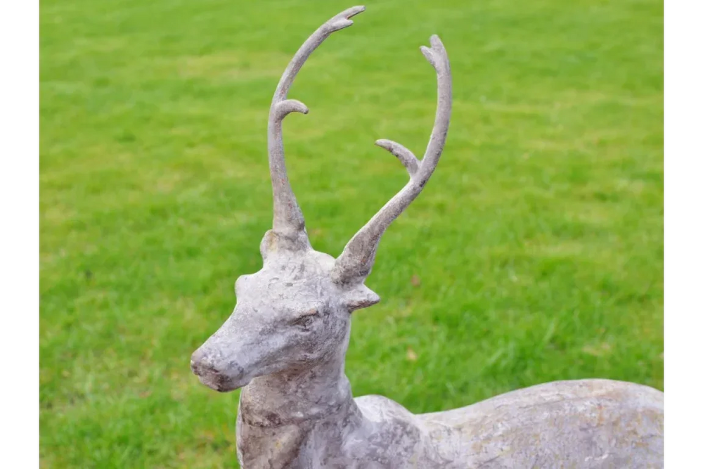 Concrete stag garden ornament with antlers on green lawn