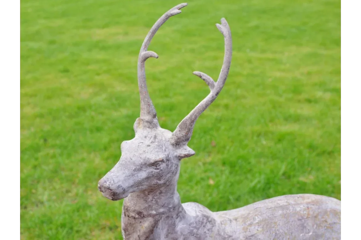 Concrete stag garden ornament with antlers on green lawn