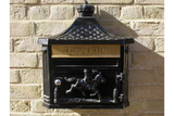 Black wall-mounted post box with gold letters slot and horse rider motif