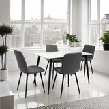 Modern dining table set with four grey padded chairs in bright room with large windows