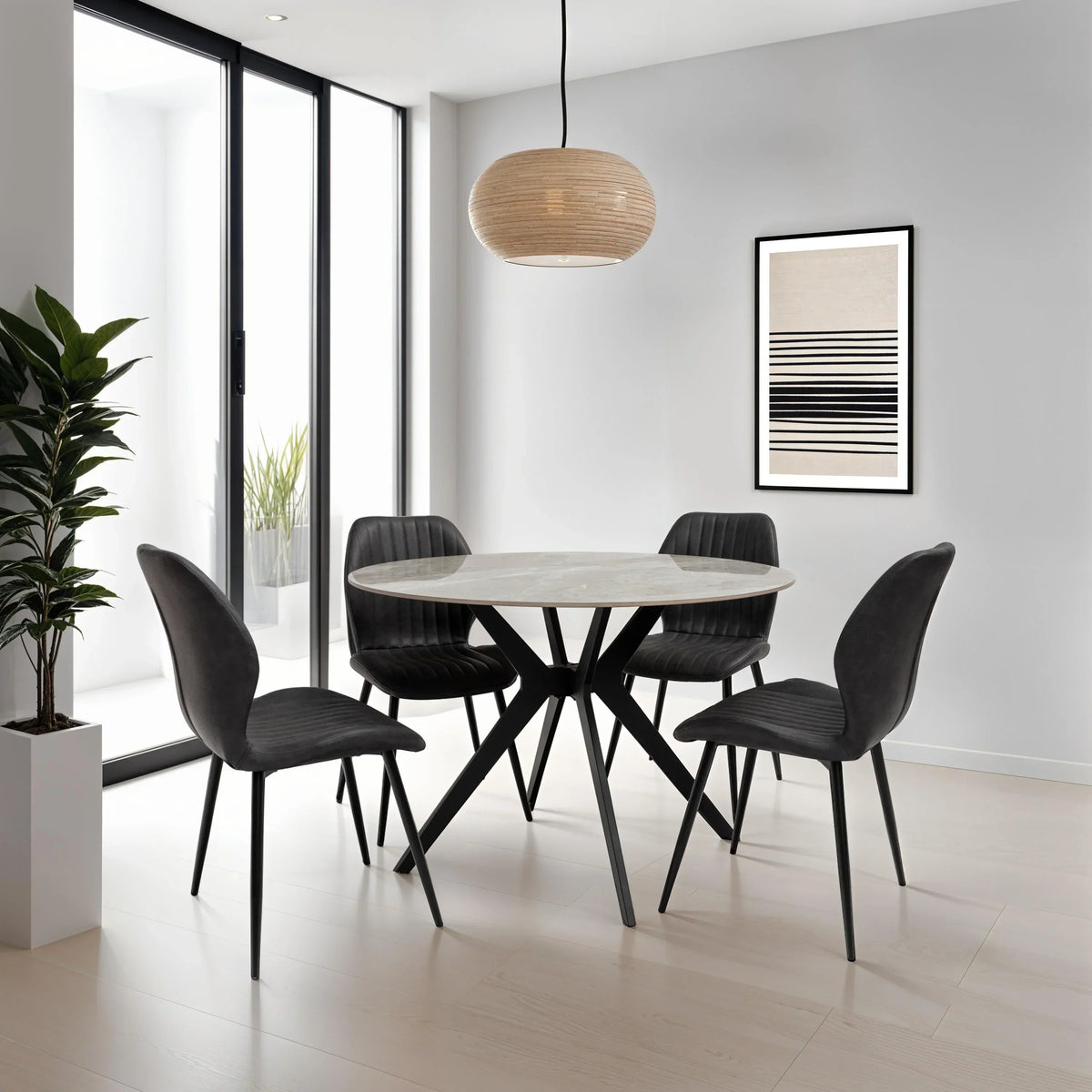 Round marble dining table with four black velvet chairs in modern dining room