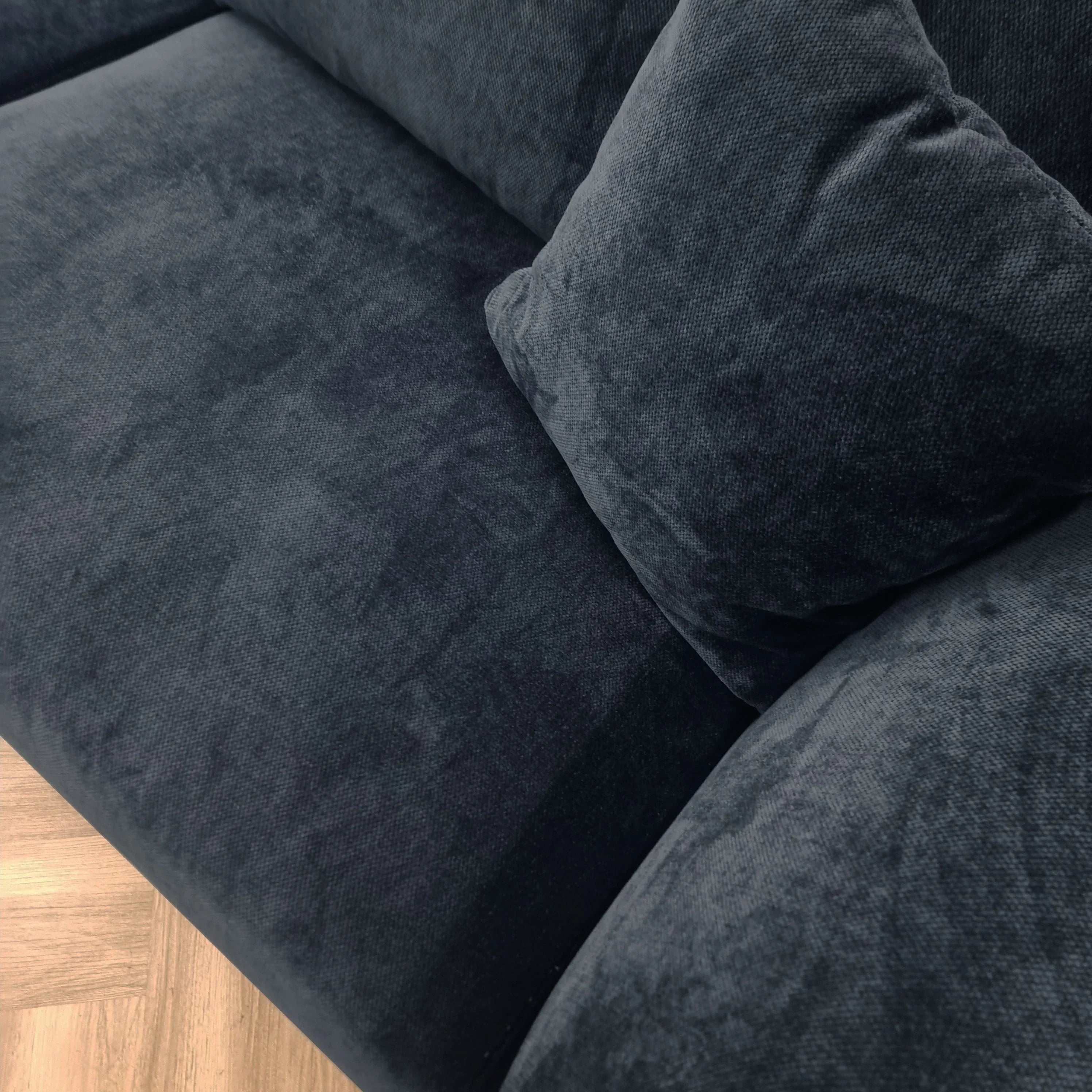 Dark grey fabric sofa seat with matching scatter cushion on wooden floor