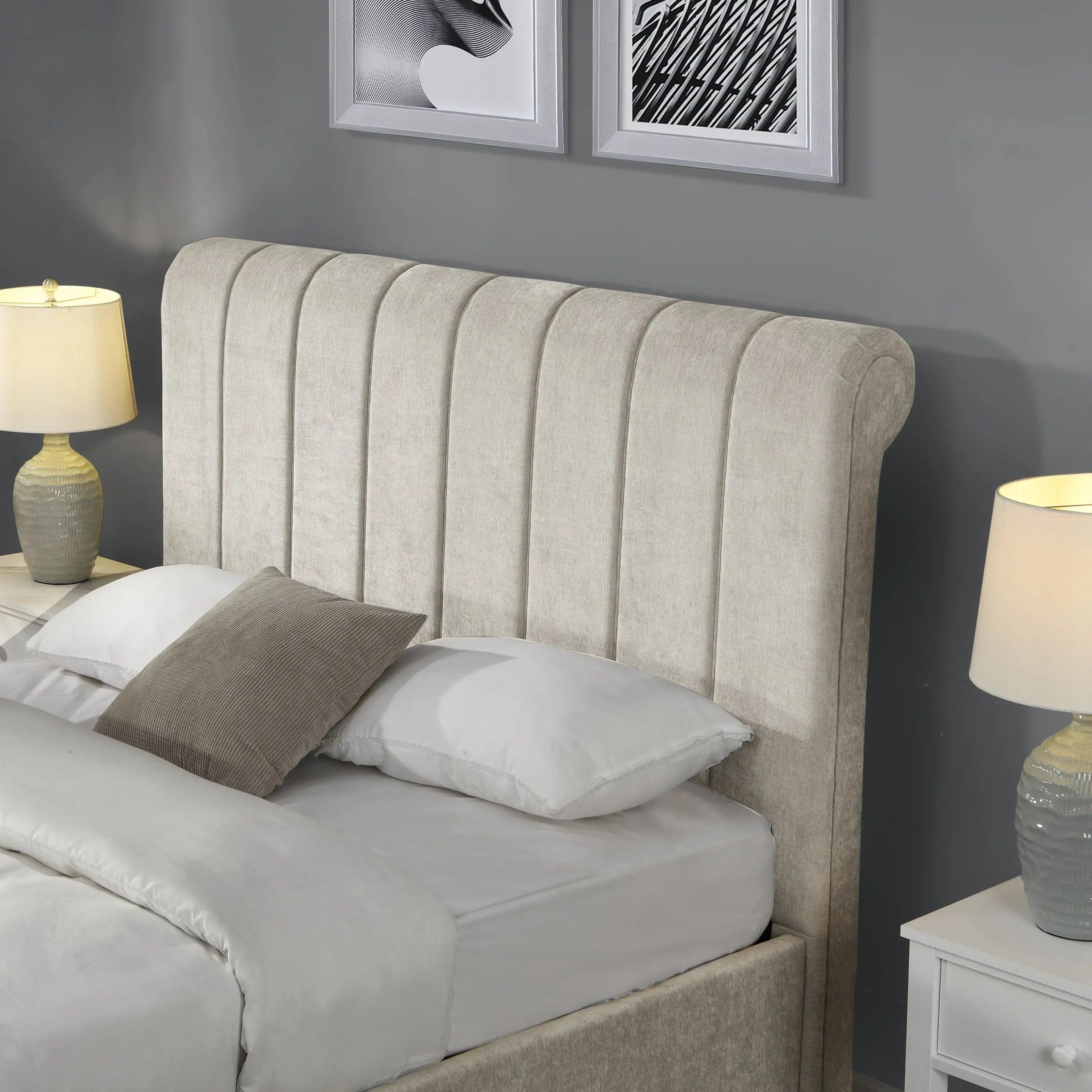 Beige upholstered bed with vertical panel headboard and pillows beside two bedside tables