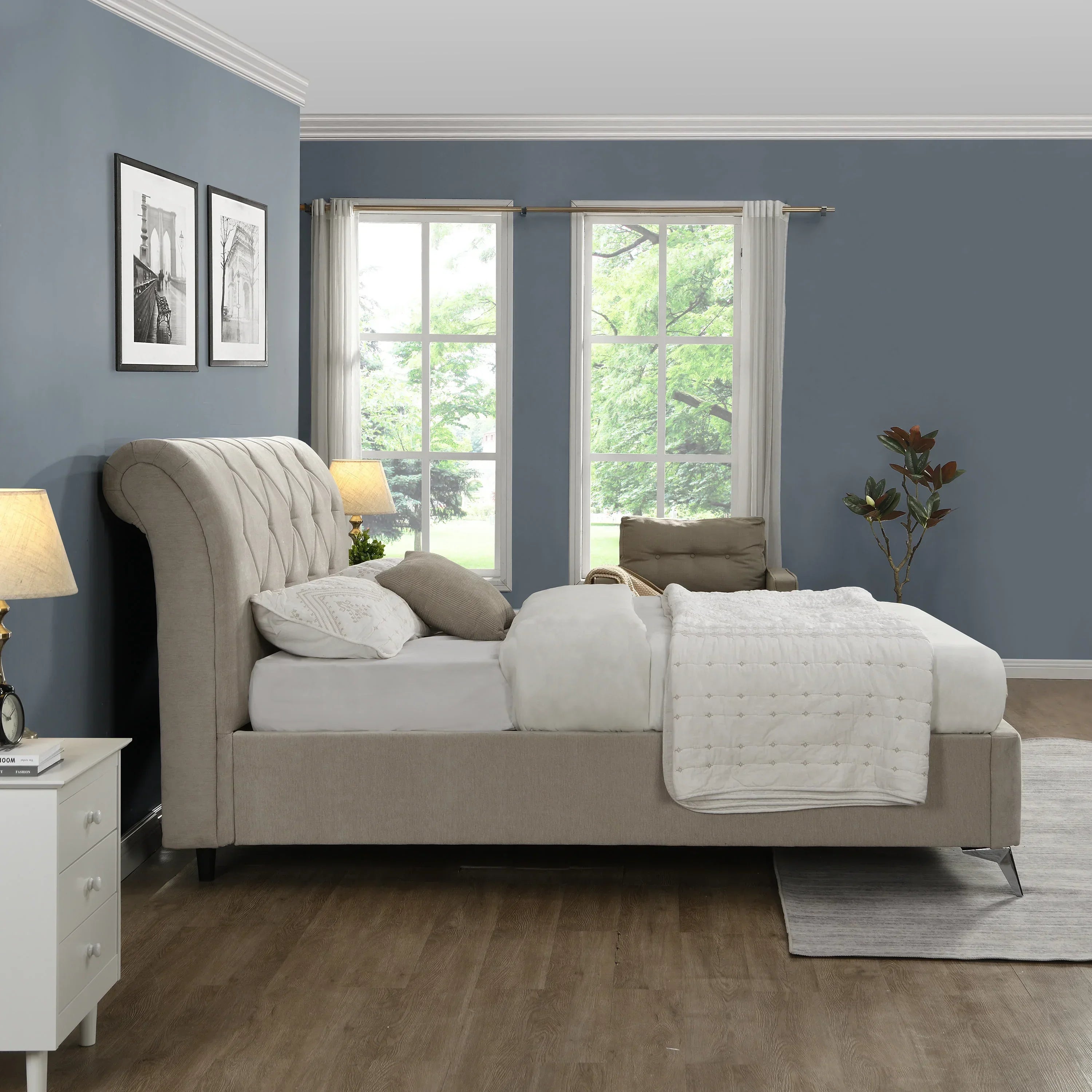 Beige upholstered bed with tufted headboard in a modern bedroom with blue walls