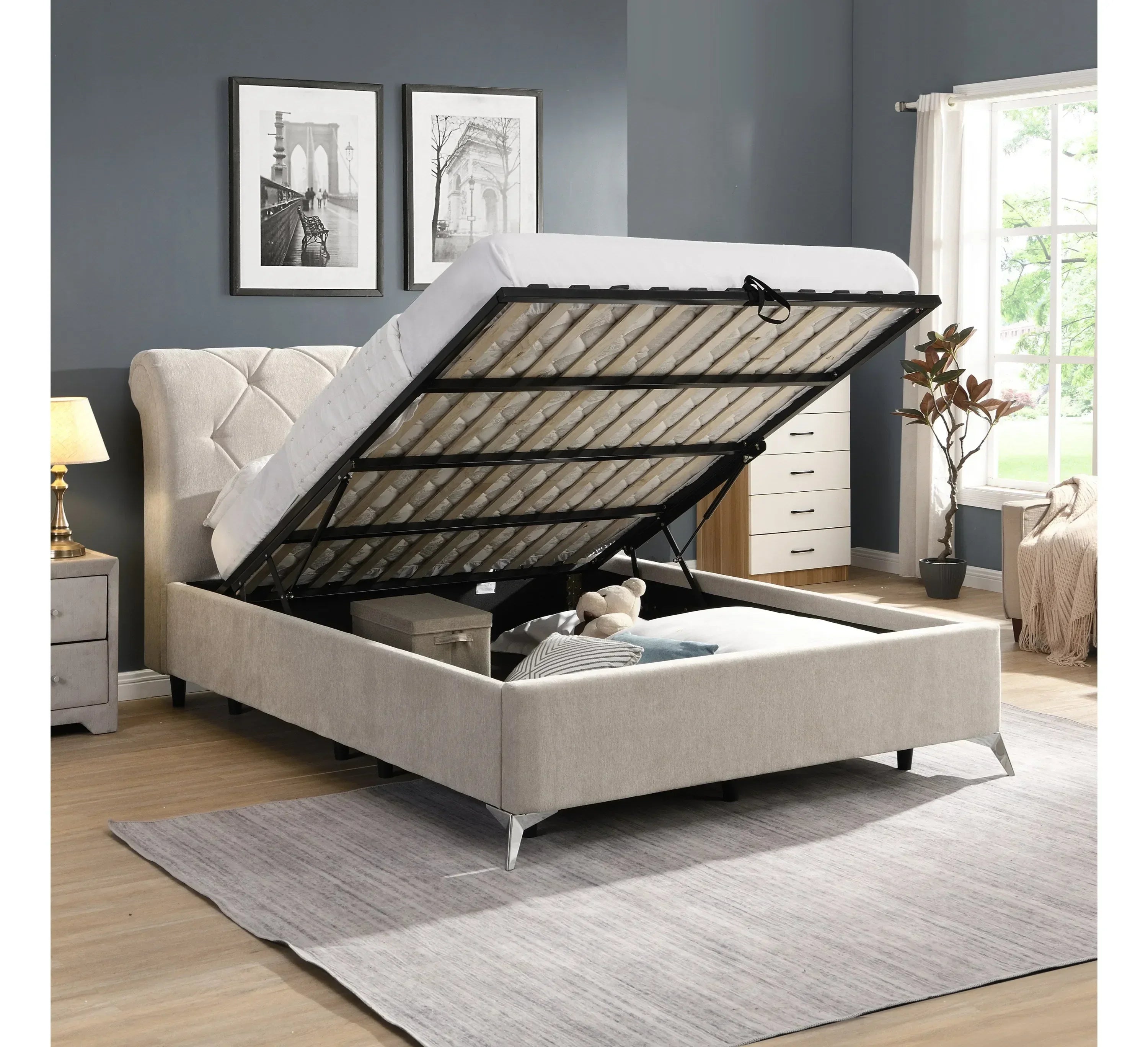 Beige ottoman storage bed with tufted headboard, mattress lifted to reveal underbed storage