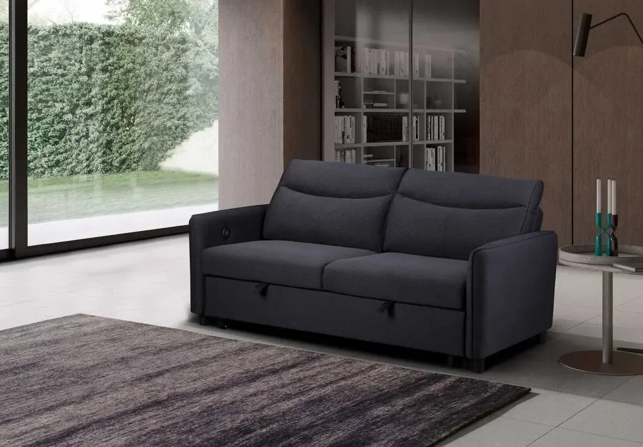 Dark grey fabric sofa with storage in modern living room by large windows and bookshelf