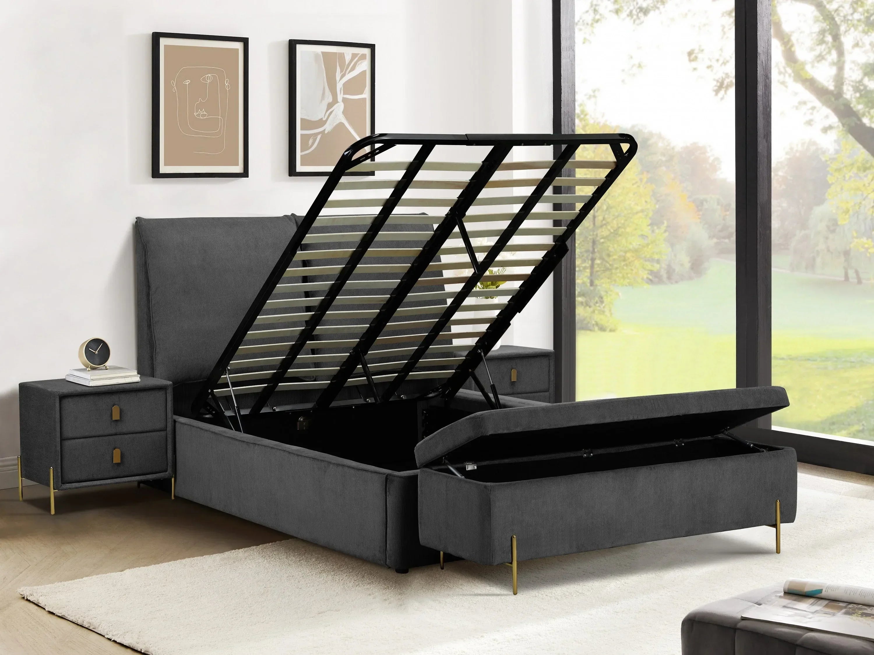 Grey upholstered ottoman bed frame with underbed storage lifted, next to bedside table