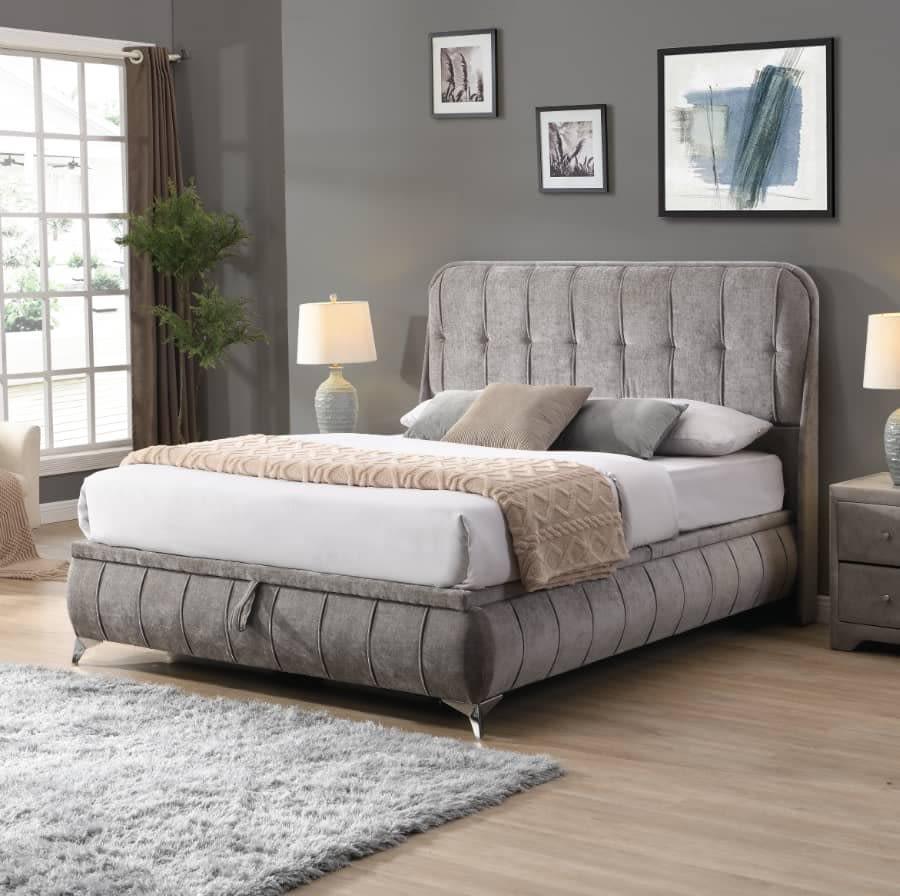 Grey upholstered bed with tall headboard and chrome legs in modern bedroom setting