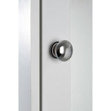 Close-up view of a sleek, modern cabinet featuring a mirrored surface and a round, metallic knob. The cabinet has a clean, minimalist design with a light-colored finish