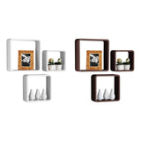 Three wall cubes in white and dark brown, arranged in a staggered pattern. The cubes are empty, showcasing their geometric design, with one cube displaying a framed photo of a landscape. The overall look is modern and stylish, suitable for home decor