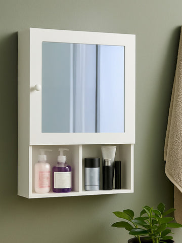 White wood mirrored cabinet with two mirrored doors and an open shelf below, displaying various bottles and containers. The cabinet is mounted on a wall with a neutral-colored background and a towel hanging nearby