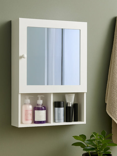 White wood mirrored cabinet with two mirrored doors and an open shelf below, displaying various bottles and containers. The cabinet is mounted on a wall with a neutral-colored background and a towel hanging nearby