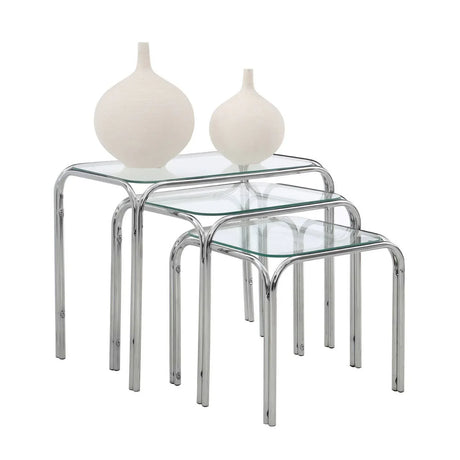 Glass nesting tables with chrome legs, decorative white vases on top