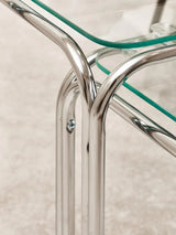 Chrome and glass coffee table corner detail with curved metal frame