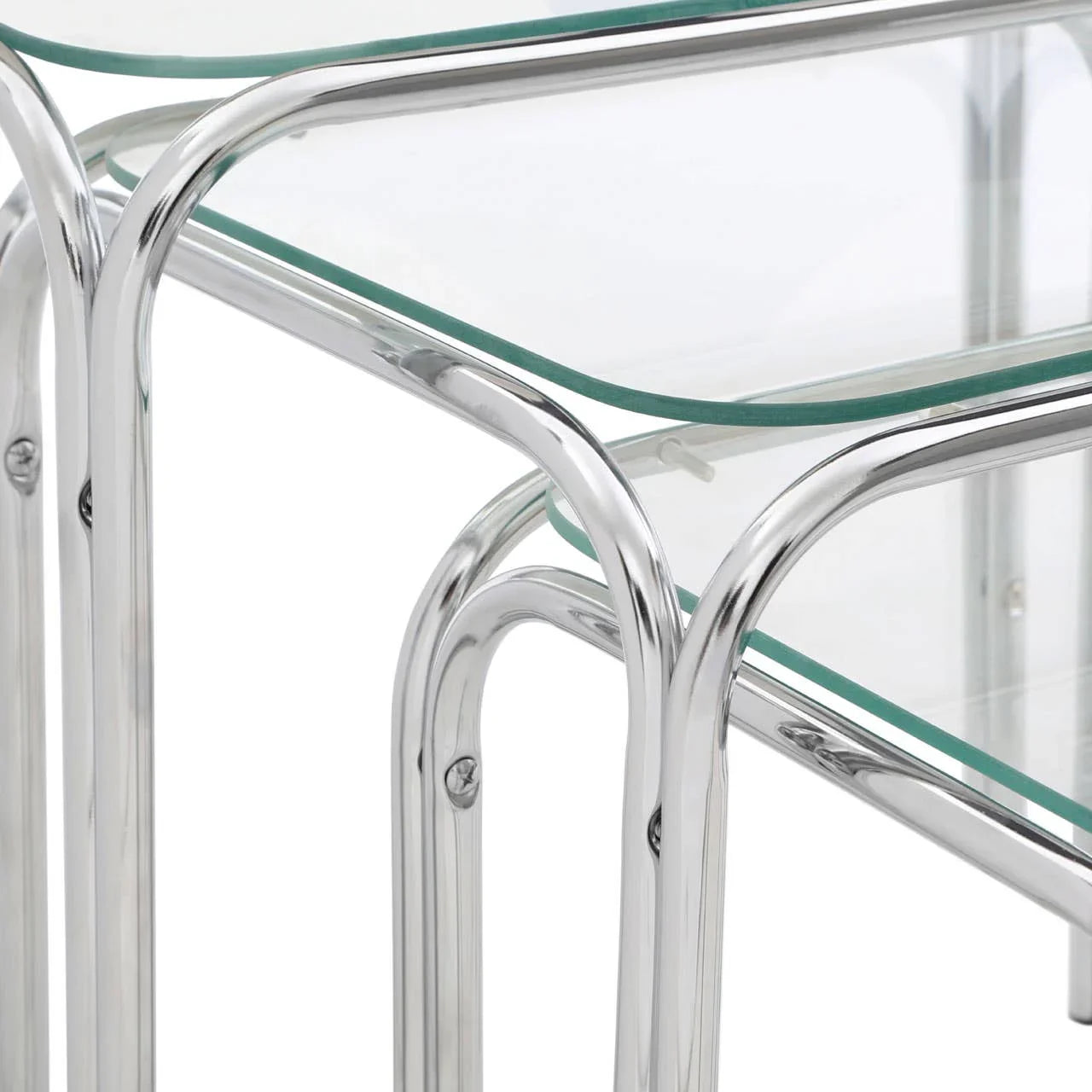 Closeup of glass nest of tables with chrome metal legs and clear tempered glass tops