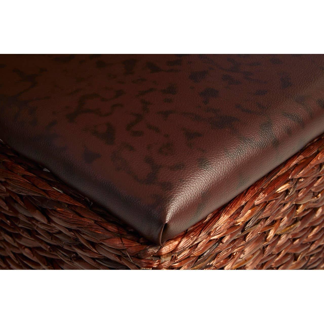 Close-up of brown faux leather seat cushion on woven rattan furniture corner