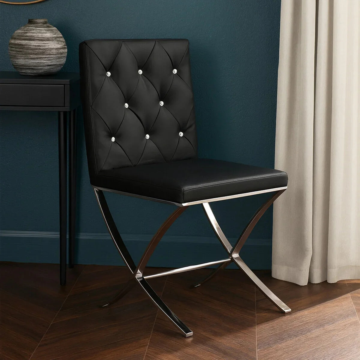 Black leather dining chair with chrome legs and button-tufted backrest