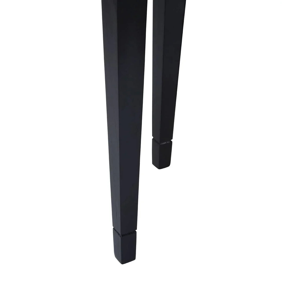 Closeup of black wooden dining table legs with tapered square design