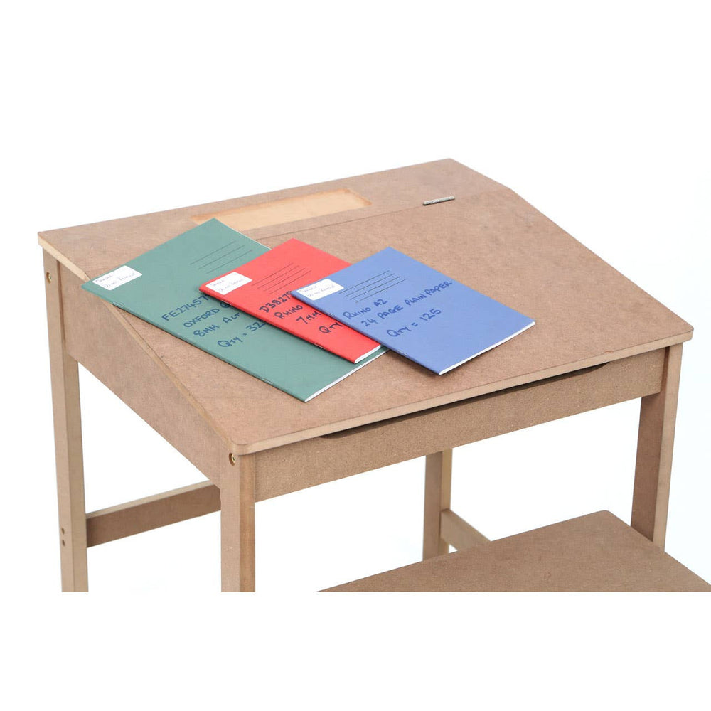 Natural wood desk with a slanted top, featuring three colorful notebooks in red, green, and blue placed on the surface. The desk has a lower shelf for additional storage. A matching stool is positioned nearby, complementing the desk's design