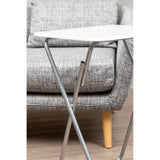 Folding table with a white top and silver metal legs positioned next to a gray upholstered sofa with wooden legs. The table is compact and designed for easy storage, complementing the modern living room setting