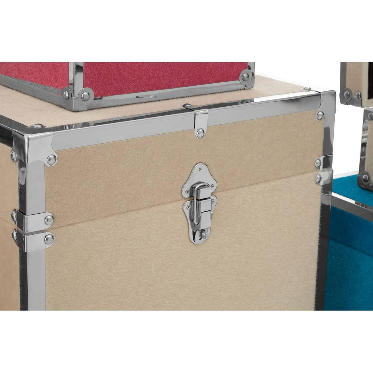 Beige storage trunk with chrome metal edges and secure latch, stacked with colored trunks