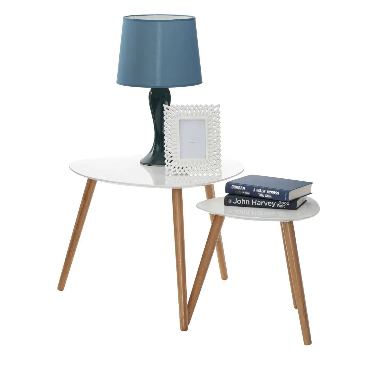Set of two round white side tables with wooden legs, styled with lamp, books and photo frame