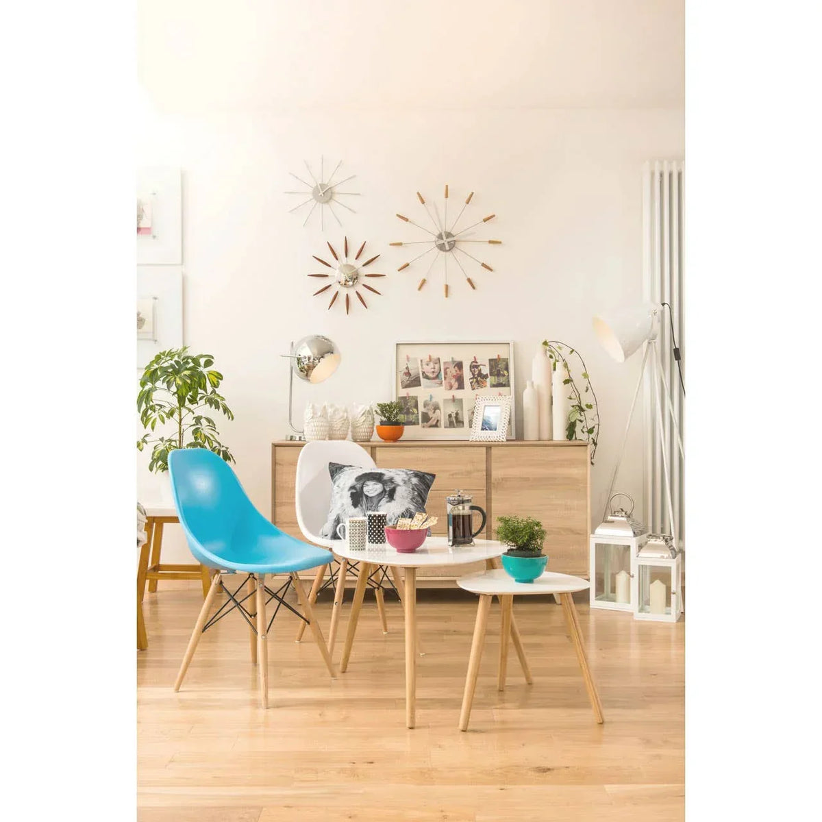 Modern living room with blue accent chair, wooden coffee tables, and sideboard decor