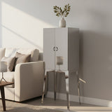 A modern stainless steel two-door cabinet with a sleek white finish, featuring a round handle and standing on slender metallic legs. The cabinet is positioned next to a cozy sofa adorned with light-colored cushions, and a decorative butterfly sculpture is placed on top, adding a touch of elegance to the setting. The background showcases a softly lit room with neutral wall colors