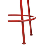 A close-up view of a red metal stool featuring a circular footrest and slender legs, showcasing a modern and industrial design. The vibrant red finish adds a pop of color, while the sturdy construction suggests durability