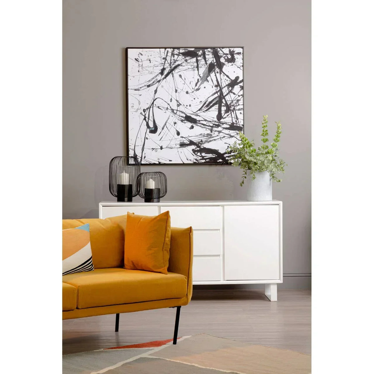 Modern yellow sofa with cushions and white sideboard in contemporary living room