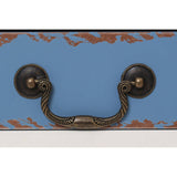 Close-up view of a blue side table featuring a decorative design and an antique-style brass handle. The handle is mounted on a contrasting surface, highlighting the craftsmanship and color contrast of the piece