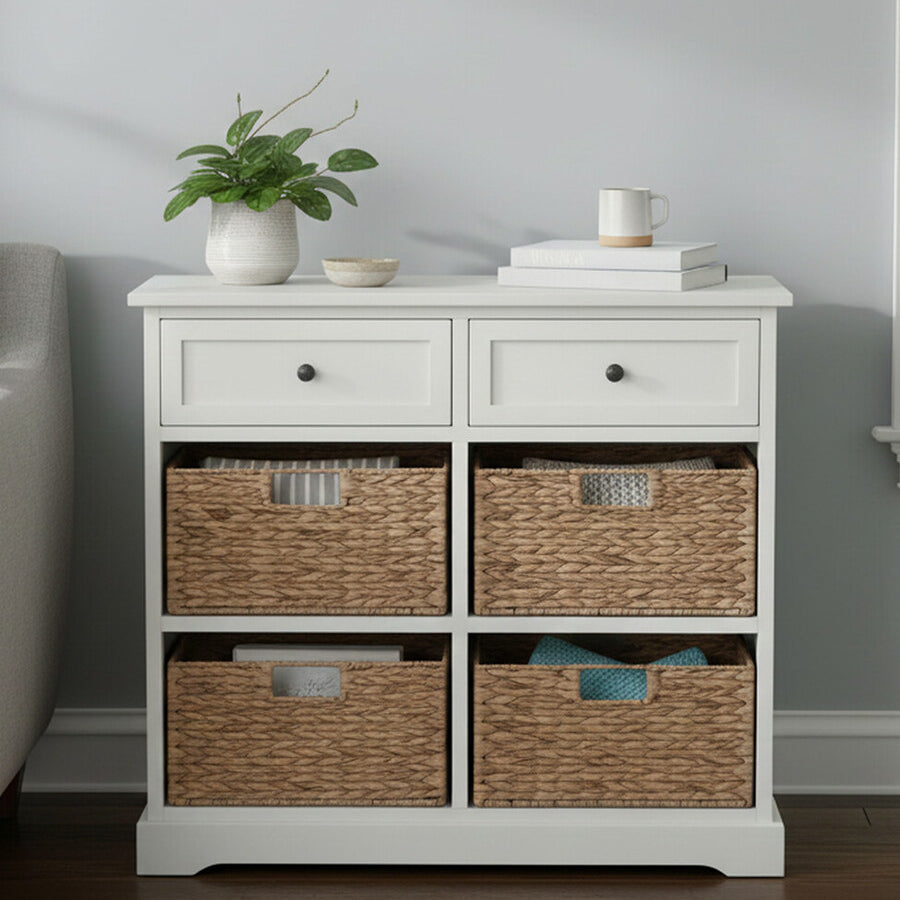 Vermont Ivory cabinet featuring two upper drawers and four woven baskets in a natural finish, set against a light-colored wall with a small potted plant and decorative items on top. The cabinet has a clean, modern design with a smooth surface and subtle hardware