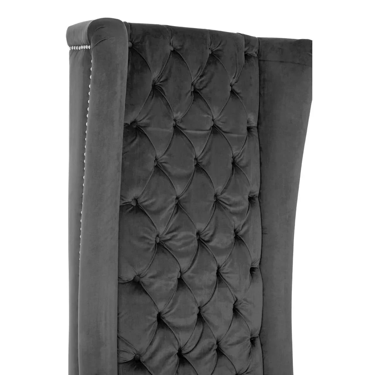 Dark grey velvet upholstered bed headboard with deep button tufting and nailhead trim detail