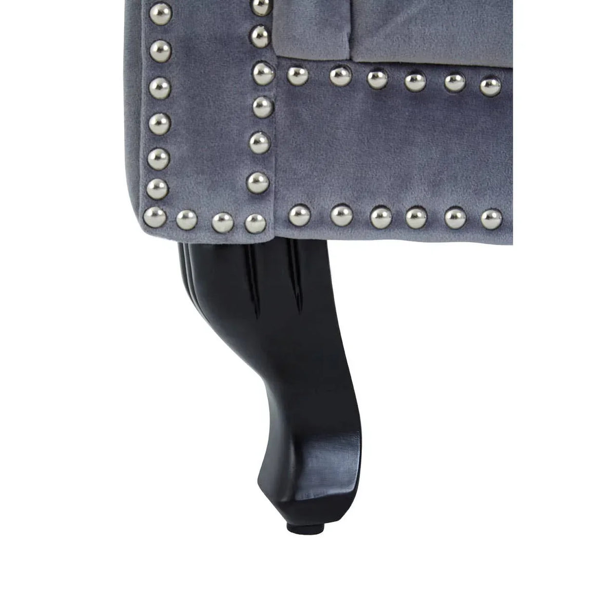Close up of grey upholstered sofa leg with silver stud detailing and black wooden foot