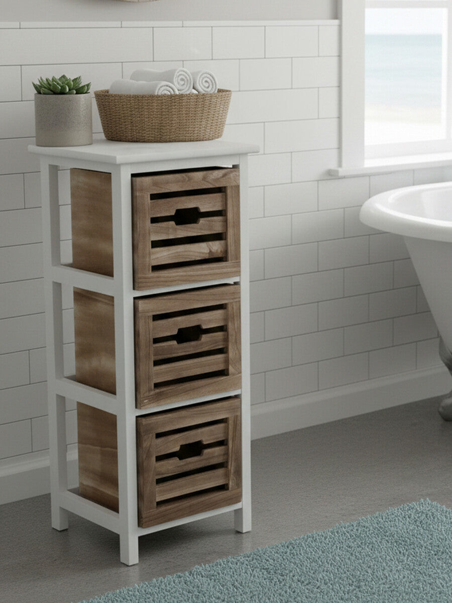 Three-drawer chest with a white wooden frame and woven baskets for storage, placed next to a bathtub in a bright bathroom setting. A decorative bowl sits on top of the chest, and a textured rug is visible on the floor