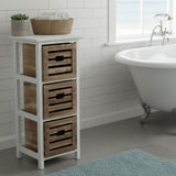 Three-drawer chest with a white frame and natural woven baskets, placed beside a freestanding bathtub in a bright bathroom setting. A decorative bowl sits on top of the chest, and a soft blue rug is visible on the floor