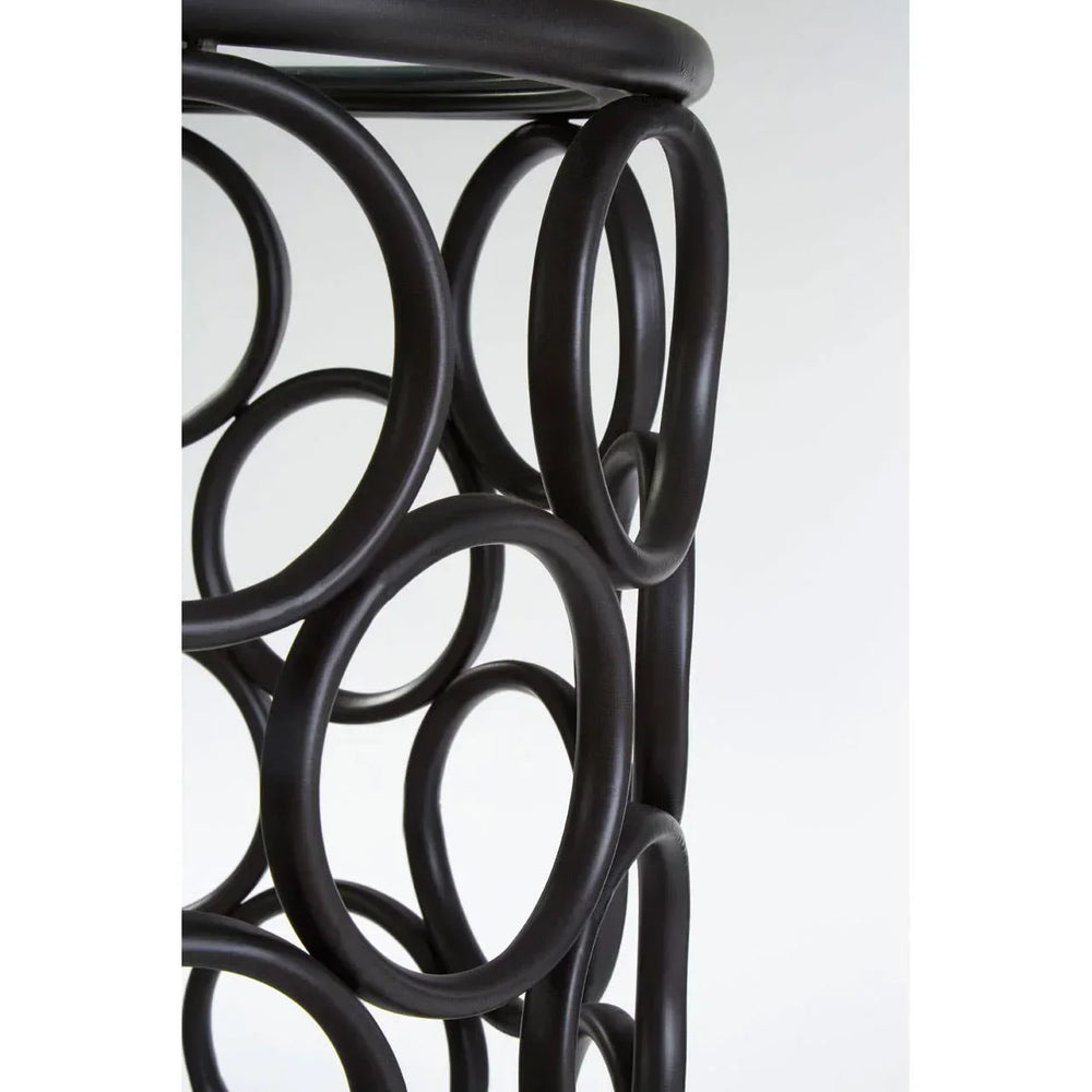 Closeup of black metal side table with circular frame and glass top